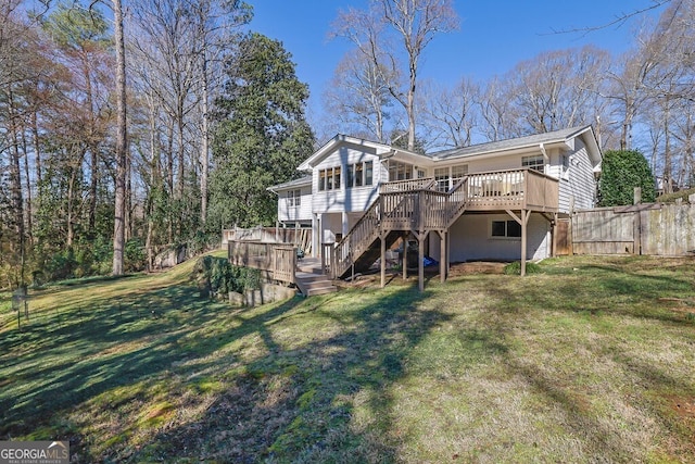 rear view of house featuring stairway, a wooden deck, fence, and a yard