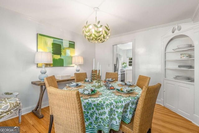 dining space featuring light wood-type flooring, baseboards, ornamental molding, and a notable chandelier