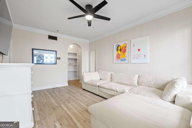 living room featuring arched walkways, visible vents, ornamental molding, ceiling fan, and light wood-type flooring