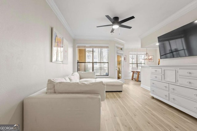 interior space with light wood-style floors, ornamental molding, baseboards, and a ceiling fan