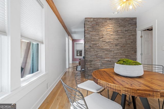 dining room featuring baseboards, light wood finished floors, and a notable chandelier