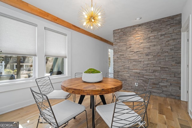 dining room featuring beam ceiling, visible vents, a notable chandelier, and wood finished floors