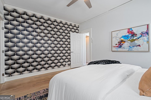 bedroom with ornamental molding, a ceiling fan, baseboards, and wood finished floors