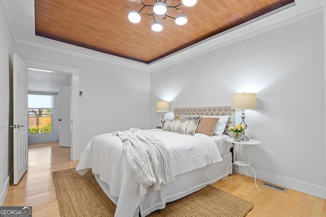 bedroom with wood ceiling, baseboards, a raised ceiling, and wood finished floors