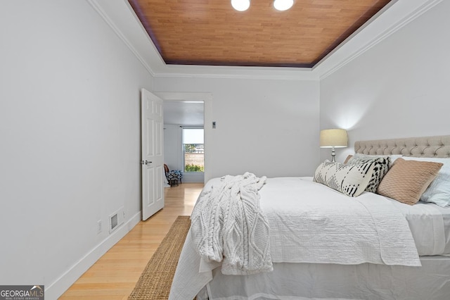 bedroom featuring ornamental molding, a raised ceiling, wood ceiling, and light wood-style floors