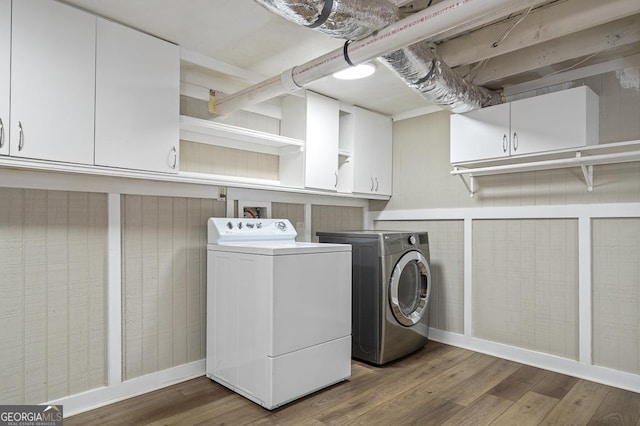 laundry area featuring cabinet space, washer and clothes dryer, and wood finished floors