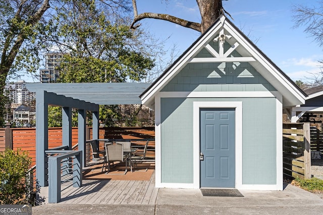 view of shed featuring outdoor dining area, fence, and a pergola