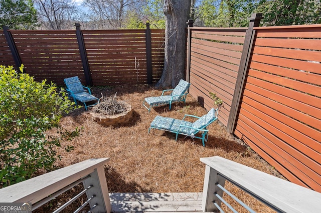 view of yard with an outdoor fire pit and a fenced backyard