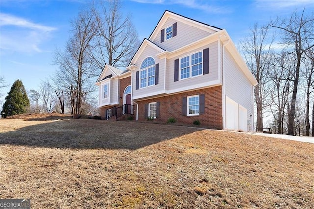 view of front of house with a garage, brick siding, and driveway