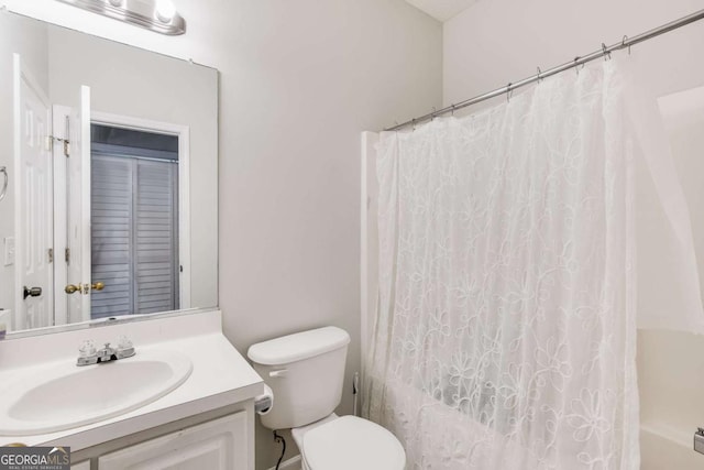 bathroom with toilet, shower / tub combo, and vanity