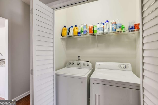 clothes washing area with laundry area, baseboards, and separate washer and dryer