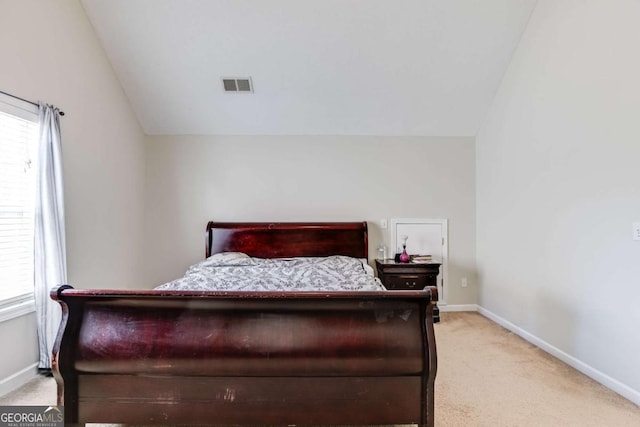 bedroom featuring light carpet, baseboards, visible vents, and lofted ceiling