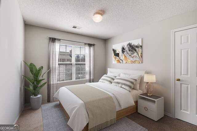 carpeted bedroom with visible vents and a textured ceiling