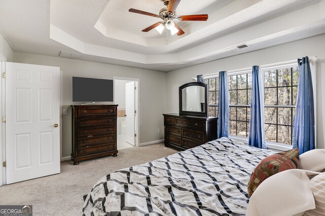 bedroom with baseboards, visible vents, a raised ceiling, a ceiling fan, and carpet floors