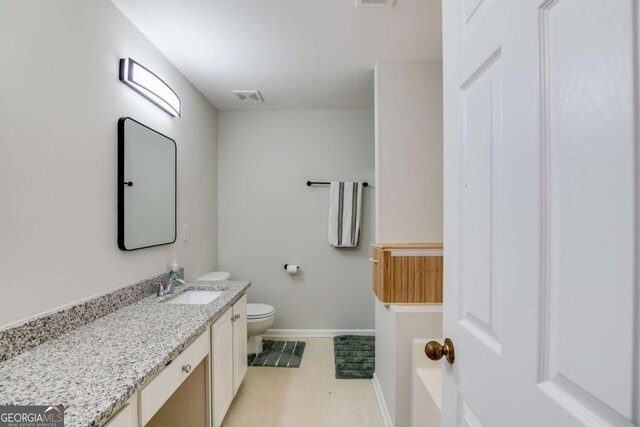 bathroom with toilet, baseboards, visible vents, and vanity