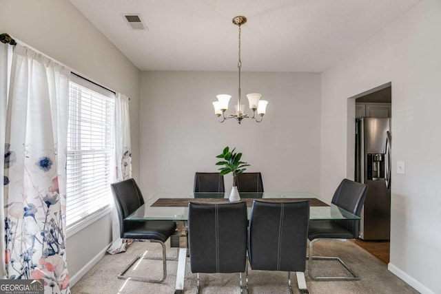 dining room featuring baseboards, carpet floors, visible vents, and an inviting chandelier