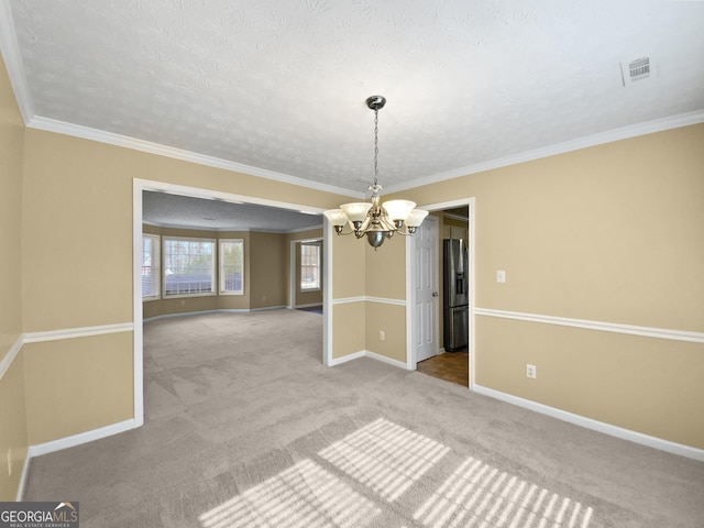 unfurnished dining area with a chandelier, a textured ceiling, carpet flooring, baseboards, and crown molding