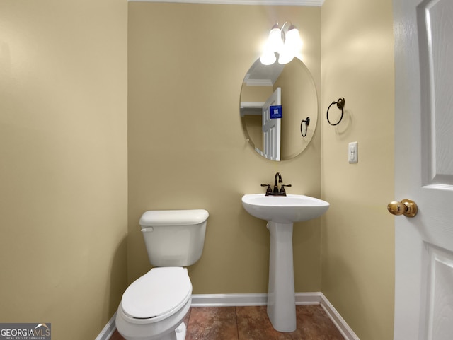 half bathroom with toilet and baseboards