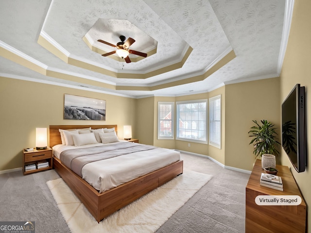 bedroom featuring light carpet, baseboards, a tray ceiling, and ornamental molding