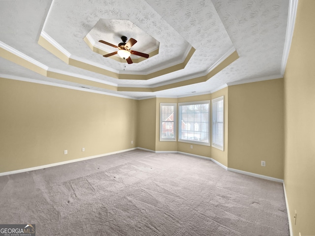 empty room featuring ceiling fan, carpet, a raised ceiling, and baseboards