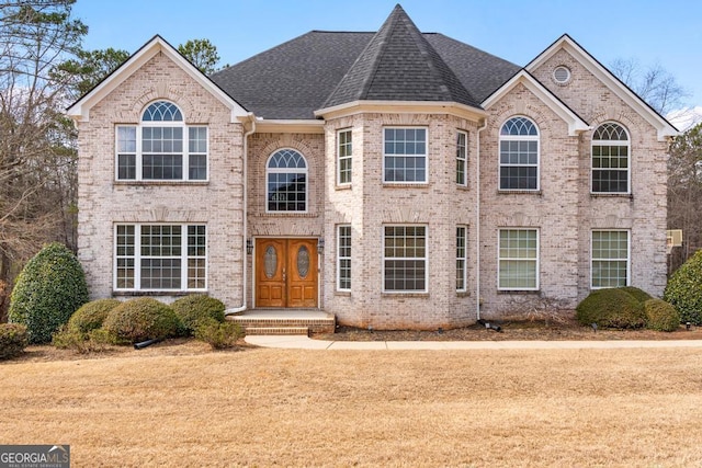 view of front of property with brick siding and a shingled roof