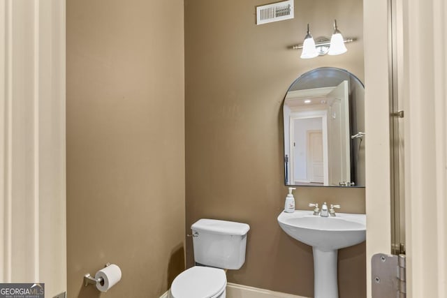 bathroom with visible vents, a sink, and toilet