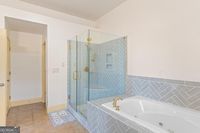 full bath featuring a stall shower, tile patterned flooring, and a jetted tub