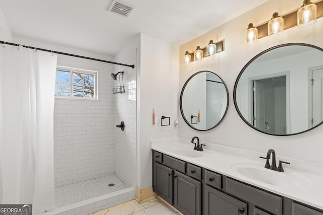 bathroom featuring double vanity, visible vents, a sink, and tiled shower