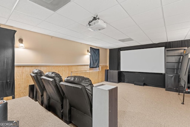 cinema with a paneled ceiling, a wainscoted wall, visible vents, and carpet flooring