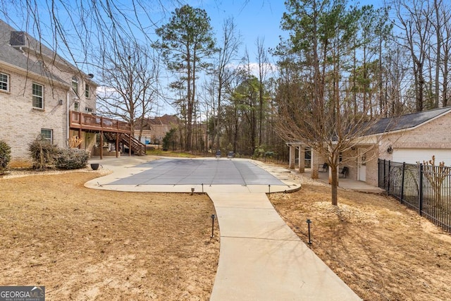 exterior space featuring stairs, fence, a deck, and a patio