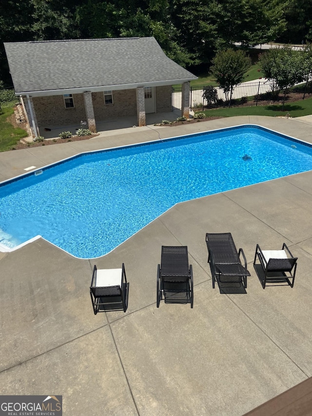 view of swimming pool featuring a fenced in pool, a patio, a storage structure, fence, and an outdoor structure