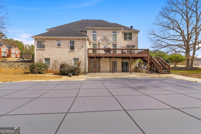 rear view of property featuring a patio, fence, a wooden deck, and stairs