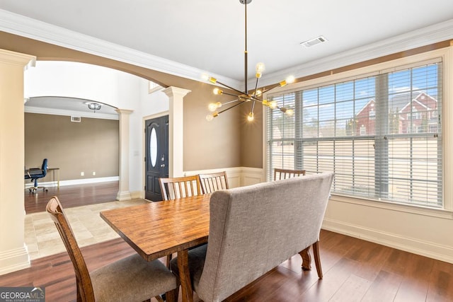 dining area with visible vents, arched walkways, ornamental molding, wood finished floors, and ornate columns