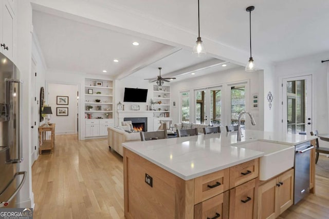 kitchen with light wood finished floors, appliances with stainless steel finishes, a sink, and french doors