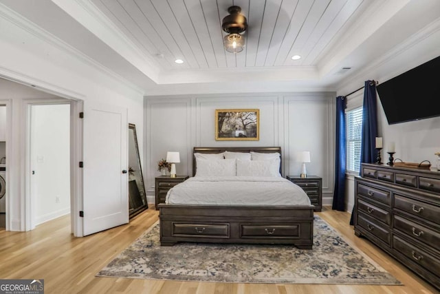 bedroom featuring wooden ceiling, a tray ceiling, and light wood finished floors