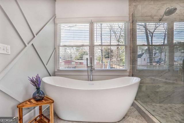 full bath with a freestanding bath, marble finish floor, and a tile shower