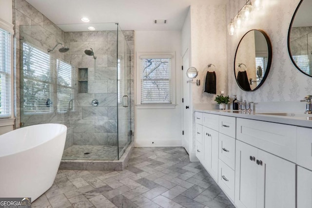 full bath featuring a stall shower, baseboards, visible vents, vanity, and a freestanding tub