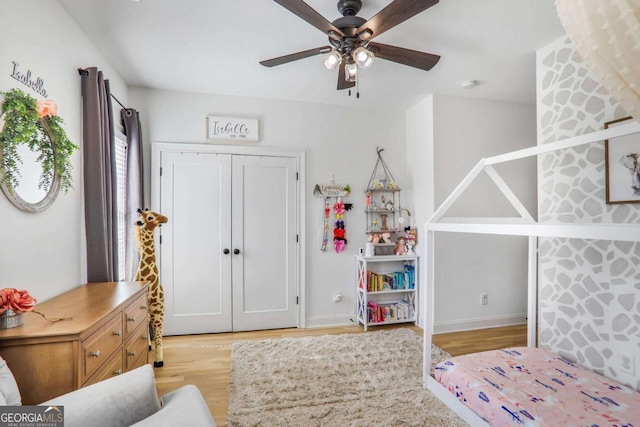 bedroom with baseboards, light wood-style flooring, and a ceiling fan