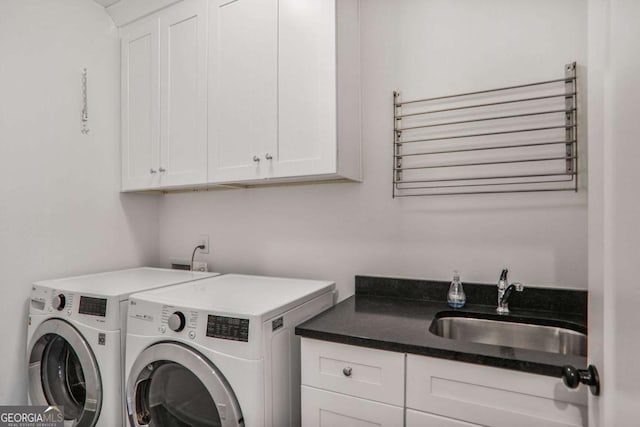 washroom with cabinet space, independent washer and dryer, and a sink