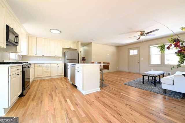 living area featuring crown molding, visible vents, light wood finished floors, and ceiling fan