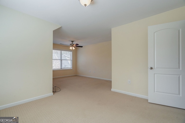 unfurnished room with carpet floors, baseboards, and a ceiling fan