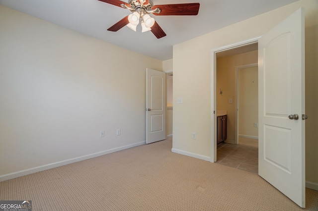 unfurnished bedroom featuring baseboards, a ceiling fan, and light colored carpet