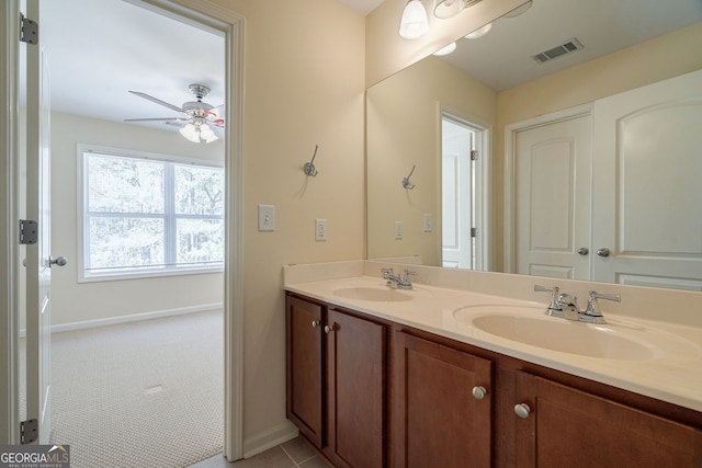 bathroom featuring a ceiling fan, visible vents, a sink, and double vanity