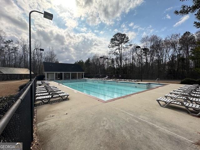 community pool featuring a patio area and fence