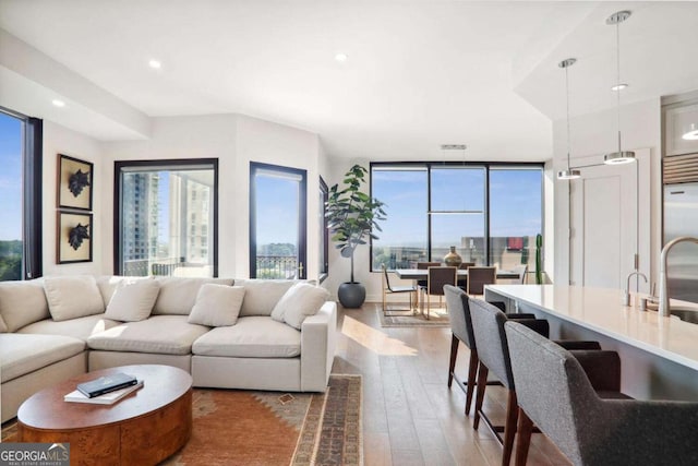 living area featuring floor to ceiling windows, wood finished floors, and recessed lighting