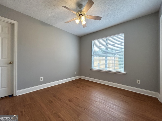 empty room featuring dark wood-style flooring and baseboards