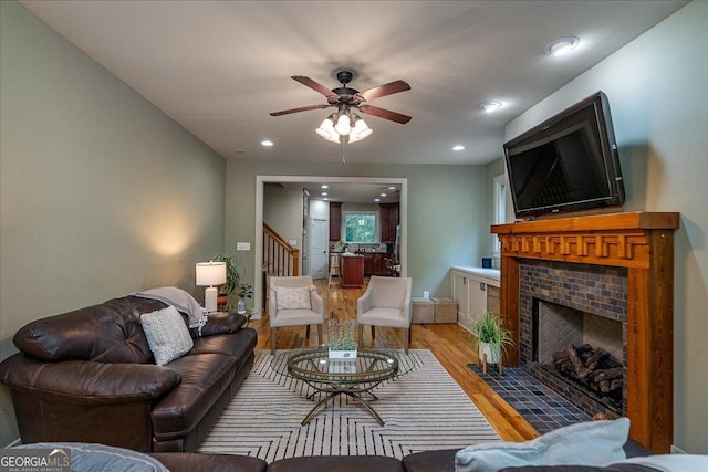1190 Cobblestone Ln, Bogart, GA 30622 - living room with a brick fireplace, stairway, light wood-type flooring, ceiling fan, and recessed lighting
