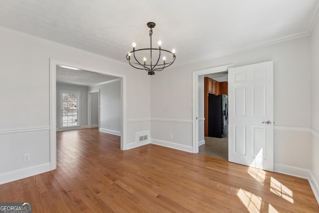 unfurnished dining area featuring a chandelier, light wood-type flooring, visible vents, and baseboards