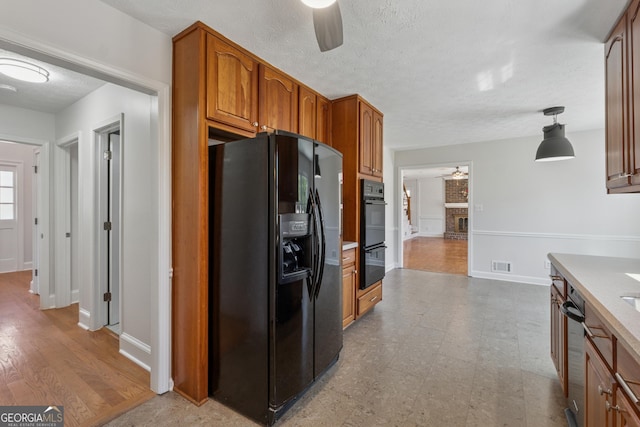 kitchen with light floors, visible vents, a ceiling fan, black appliances, and brown cabinetry