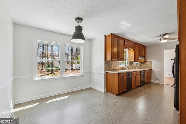 kitchen featuring decorative backsplash, dishwashing machine, brown cabinets, light countertops, and a sink